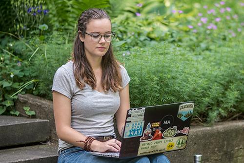 student working on laptop outside